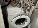 a washing machine with a bunch of clothes on top of it