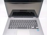 a silver laptop with a black keyboard on a white surface