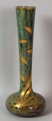 a green vase with gold designs on it on a white background