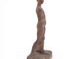 a wooden statue of a man standing on a white surface
