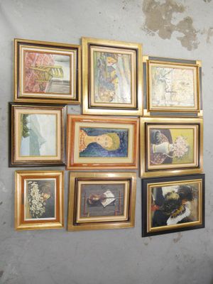 de nombreux tableaux encadrés accrochés au mur d'une pièce
