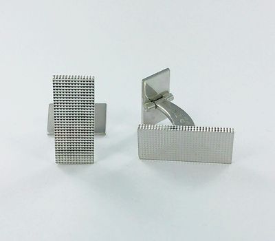 paire de boutons de manchette en argent sur fond blanc, avec un fond blanc