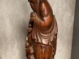 a statue of a woman holding a baby on a glass table
