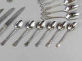 a lot of spoons and spoon knives on the table