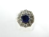 gros plan d'une bague en saphir bleu et diamant sur une surface blanche