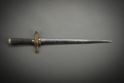 a close up of a knife on a table with a gray background