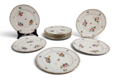 Plusieurs assiettes ornées de motifs floraux sont disposées sur une surface blanche