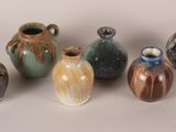 five different vases sitting next to each other on a table