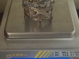 une bague en argent posée sur une balance en argent