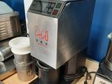 a coffee maker sitting on a table next to a blender