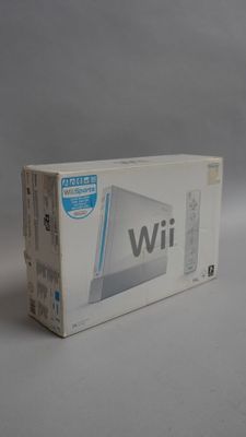 Console de jeux Nintendo Wii dans son emballage d'origine, posée sur une surface blanche avec un fond gris