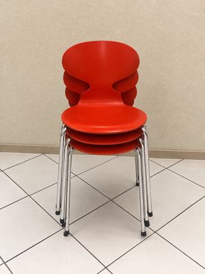 une chaise rouge posée sur un sol carrelé dans une pièce