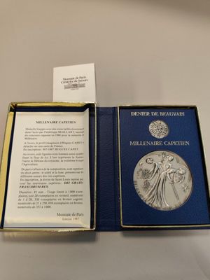 an open book with a silver medal in it sitting on a table