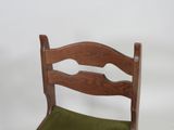 a wooden chair with a green cushion on it