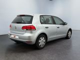 the back of a silver car is parked in a white room