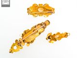 three pieces of gold jewelry on a white surface