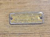 a brass plaque on the side of a wooden table