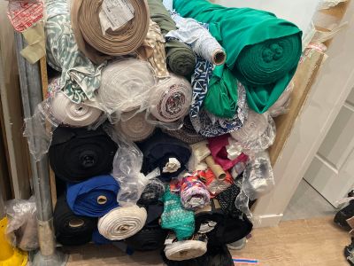 many rolls of fabric sitting on a cart in a room