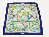 a close up of a blue and white square with birds and flowers on it