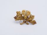 an image of a gold and white broochle with acorns on it
