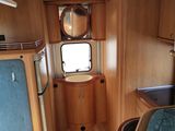 a view of the inside of a camper with a sink and mirror