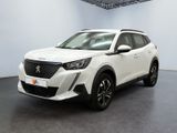Un SUV blanc est garé dans une pièce au sol noir.