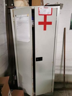 a white refrigerator with a red cross on it in a garage
