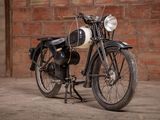 a black and white motorcycle parked in front of a brick wall