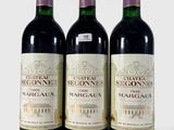 trois bouteilles de vin posées les unes à côté des autres sur une surface blanche