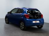 the back of a blue car with its trunk open in a room