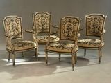 quatre chaises ornées d'un motif doré et noir, disposées dans une pièce
