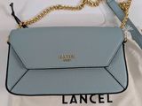 un petit sac bleu auquel est suspendue une chaîne dorée