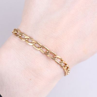 a close up of a woman ' s hand wearing a gold chain bracelet
