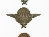 three old metal badges are displayed on a white surface
