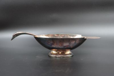 a silver bowl with a spoon in it on a table