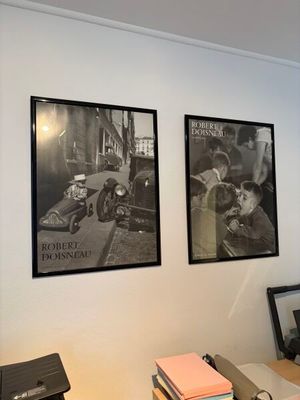 une photo d'un bureau avec un ordinateur et des photos accrochées au mur