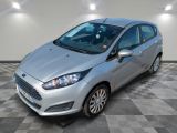 une Ford Fiesta argentée garée sur un sol à damier dans un garage