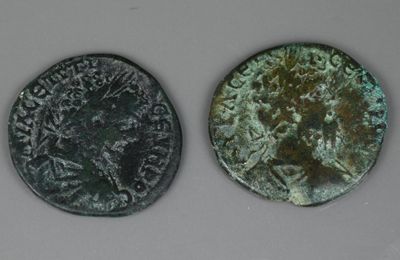deux pièces de monnaie romaines anciennes, dont l'une représente un buste et l'autre un buste
