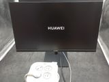 un écran d'ordinateur et un chargeur posés sur une table