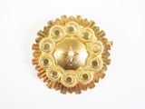 une image représentant une broche en or ornée d'une étoile au centre