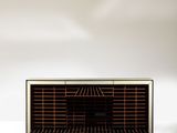 an old radio sitting on top of a white table next to a vase