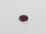 a close up of a purple gemstone on a white surface