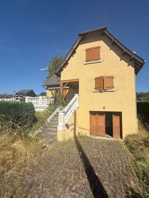 the house is yellow and has brown shutters on the windows