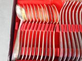 a lot of silverware in a red box on a table
