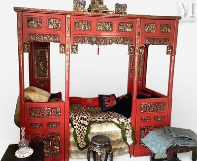 un lit rouge avec une parure de lit à imprimé léopard et un tabouret
