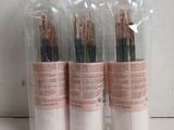 three tubes of makeup brushes in a plastic bag on a table