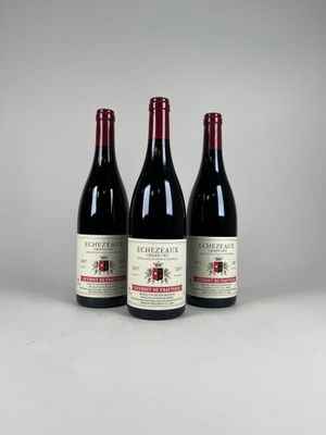 trois bouteilles de vin rouge posées côte à côte sur une table