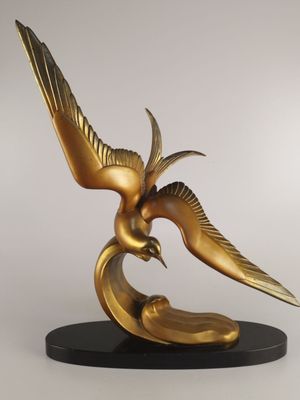 statue d'un oiseau doré sur un socle noir, sur fond blanc