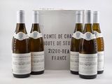trois bouteilles de vin sont posées devant une boîte de vin