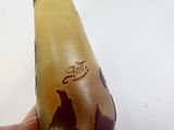 une main tenant une banane sur laquelle figurent des motifs marron et noirs